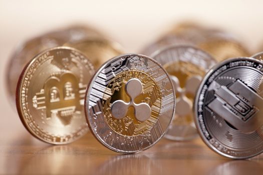 several aligned crypto currency coins on top of wooden table.