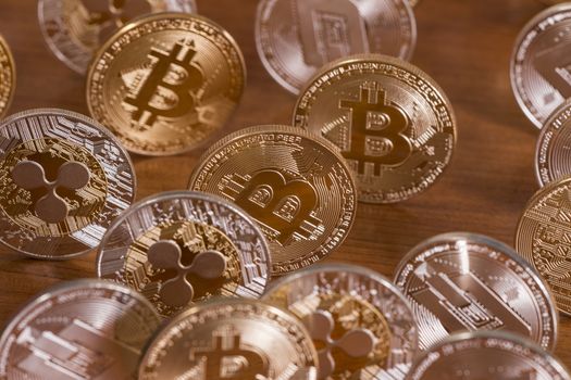 several aligned crypto currency coins on top of wooden table.