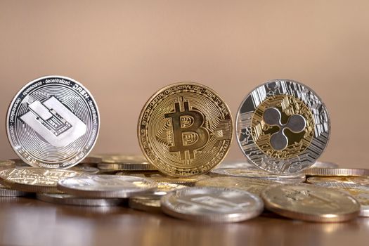 several aligned crypto currency coins on top of wooden table.