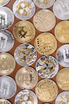 several aligned crypto currency coins on top of wooden table.