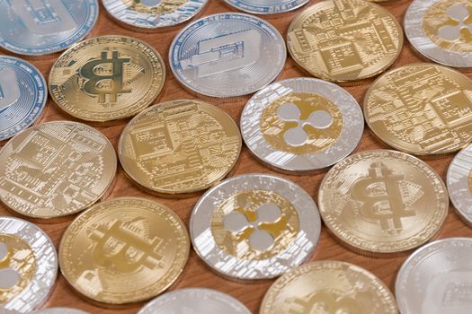 several aligned crypto currency coins on top of wooden table.