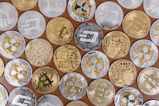 several aligned crypto currency coins on top of wooden table.