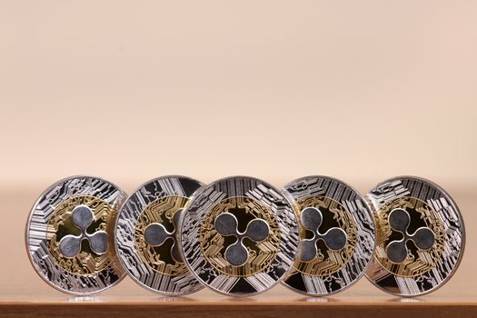 several aligned ripple coins on top of wooden table.