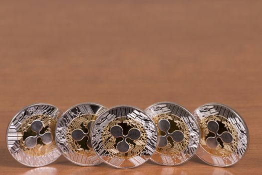 several aligned ripple coins on top of wooden table.