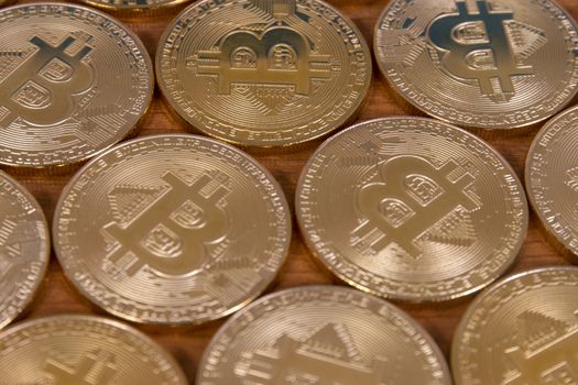 several golden bitcoins on top of wooden table.