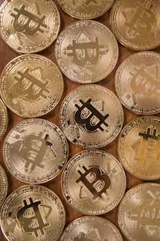 several golden bitcoins on top of wooden table.