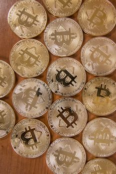 several golden bitcoins on top of wooden table.