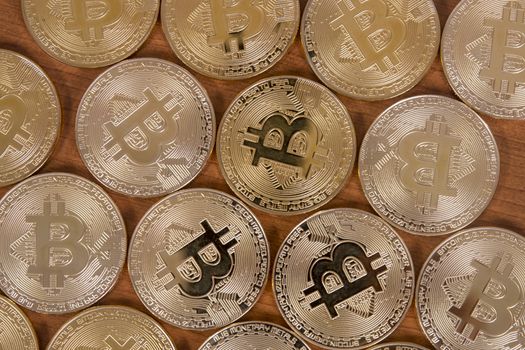 several golden bitcoins on top of wooden table.