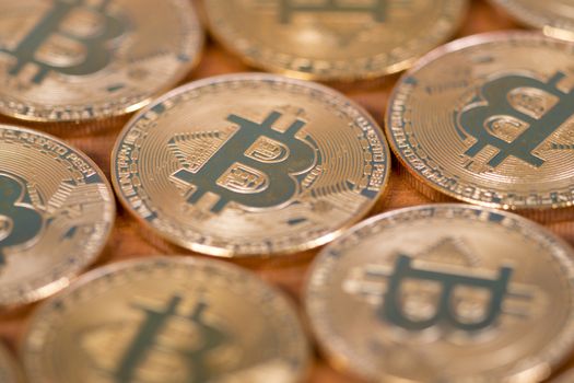 several golden bitcoins on top of wooden table.