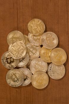 several golden bitcoins on top of wooden table.