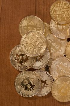 several golden bitcoins on top of wooden table.