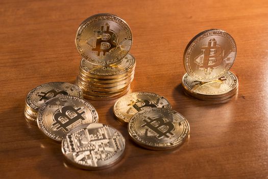 several golden bitcoins on top of wooden table.