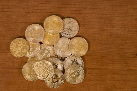 several golden bitcoins on top of wooden table.