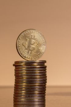 several golden bitcoins stacked on top of wooden table.