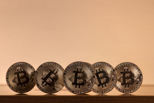 Shiny golden bitcoins on top of wooden table.