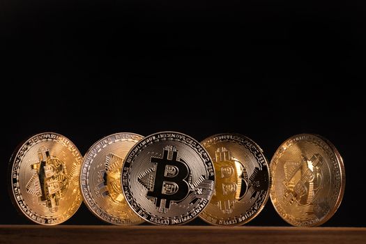 Shiny golden bitcoins on top of wooden table.