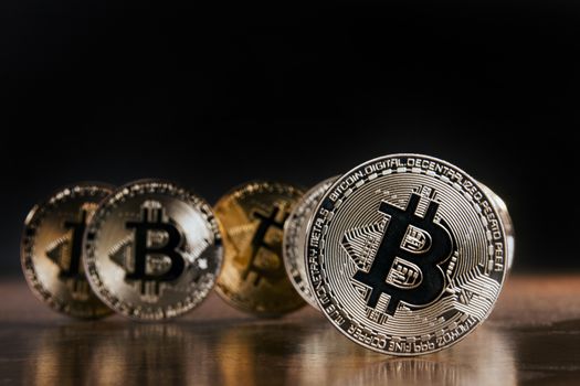 Shiny golden bitcoins on top of wooden table.