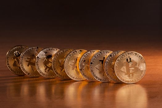 Shiny golden bitcoins on top of wooden table.