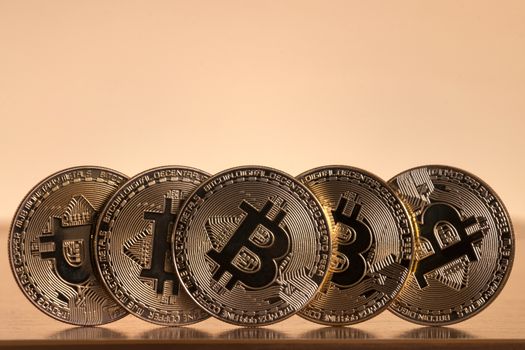 Shiny golden bitcoins on top of wooden table.