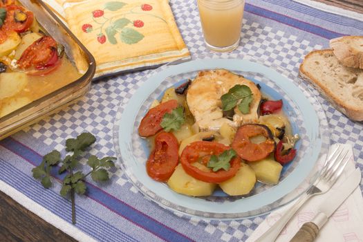 Traditional portuguese meal of fish with potatoes and tomato, made on the oven.