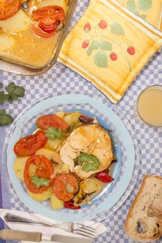 Traditional portuguese meal of fish with potatoes and tomato, made on the oven.