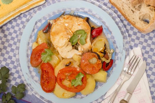 Traditional portuguese meal of fish with potatoes and tomato, made on the oven.