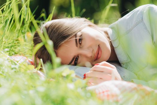 Pretty young woman laying in the grass and smiling