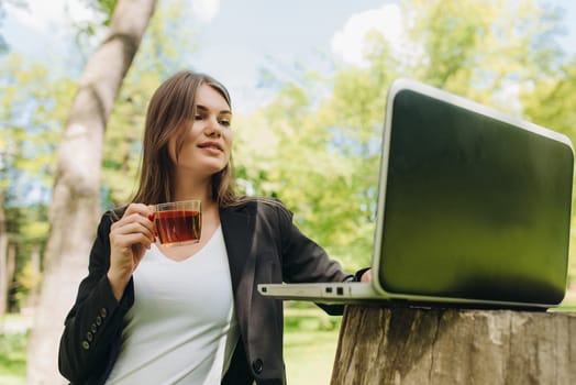 Beautiful business woman in suit using laptop computer in the park