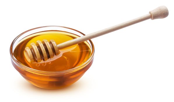 Honey stick and bowl of pouring honey isolated on white background with clipping path