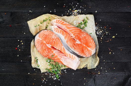 Salmon steaks on black wooden table top view