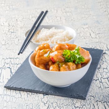 Bowl of oriental lemon chicken served with white rice.