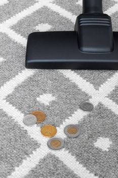 Vacuum cleaner and coins on gray carpet (Canadian money).