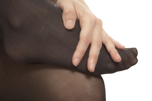 Close-up of female foot with pantyhose. Woman is rubbing her toes to relax pain.