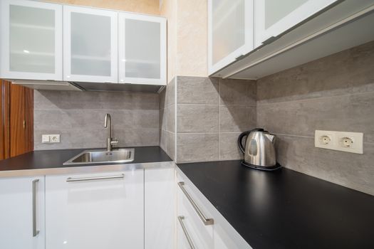 Empty modern kitchen countertop with sink and 
kettle