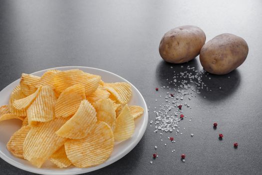 potato chips on a plate with salt and pink pepper