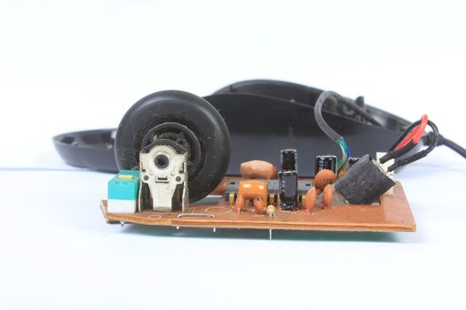 The dusty circuit board and rotating wheel inside an old computer mouse.