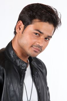 A portrait of a young handsome Indian guy wearing a black leather jacket.