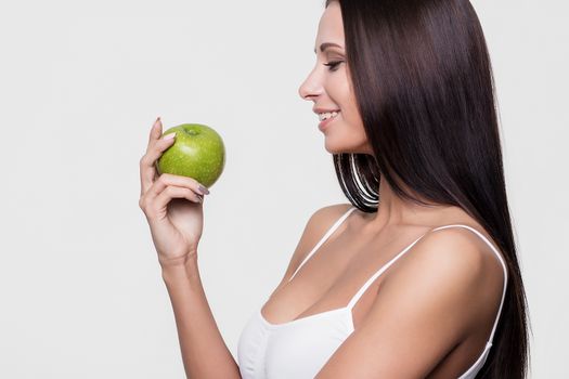 Attractive smiling woman portrait on white background with apple.