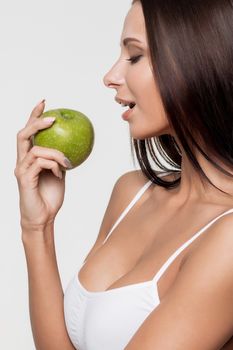 Attractive smiling woman portrait on white background with apple.