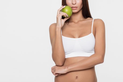 Attractive smiling woman portrait on white background with apple.