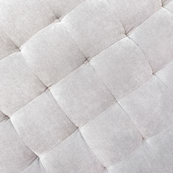 Gray buttoned fabric background. Detail of a textile ottoman. Classic style furniture. 