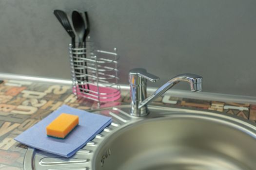 Close up of modern faucet and ceramic sink in kitchen