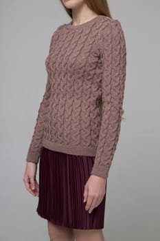 Female model corpus in knitted blouse and brown skirt on grey background