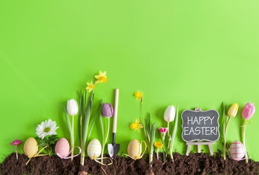 Happy easter message on a chalkboard on a flower bed background with row of painted eggs amongst flowers
