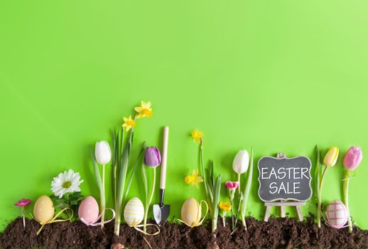 Easter sale sign on a chalkboard on a flower bed background with row of painted eggs amongst flowers