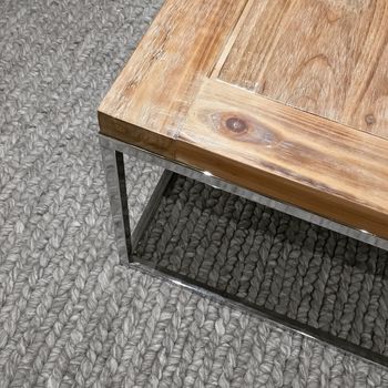 Wooden table with metal frame on gray knitted carpet. Modern design.