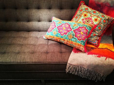 Textile sofa decorated with bright ornate cushions. Stylish furniture.