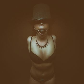 fetish dark portrait glamour girl in hat and bra with gag