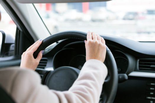 Closeup shot of woman's hands on the wheel