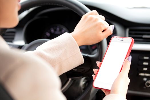 Closeup shot of female driver holding a smartphone or navigation device